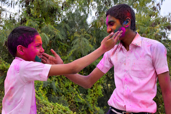 два мальчика играют в цветах в счастливой позе, концепция для индийского фестиваля Холи