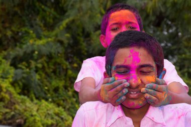İki erkek çocuk mutlu bir duruşla oynuyor, Hint festivali için konsept Holi
