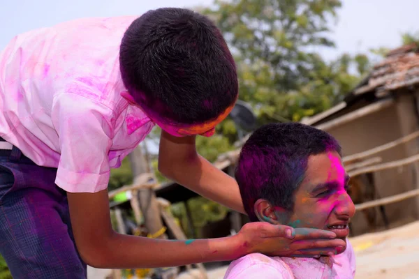 两个男孩以一种快乐的姿态在玩着五彩缤纷的游戏 这是印度音乐节的理念 — 图库照片
