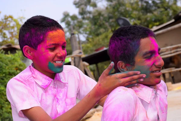 两个男孩以一种快乐的姿态在玩着五彩缤纷的游戏 这是印度音乐节的理念 — 图库照片