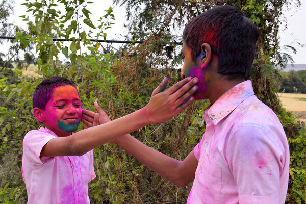 два мальчика играют в цветах в счастливой позе, концепция для индийского фестиваля Холи