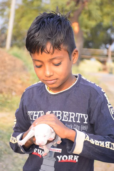 犬の子犬と幸せな姿勢でインドの農村部の子供 赤いシャツを着て — ストック写真