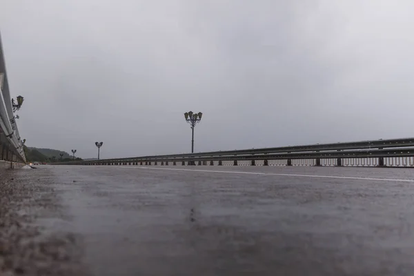 Yağmurdan sonra dağ manzaralı asfalt yol. köprü