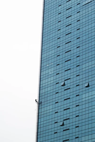 Uomo arrampicata sul muro di costruzione — Foto Stock