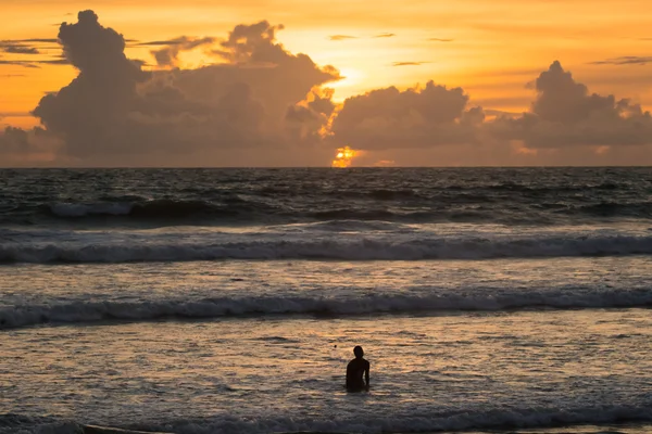 El hombre va al mar al atardecer — Foto de Stock