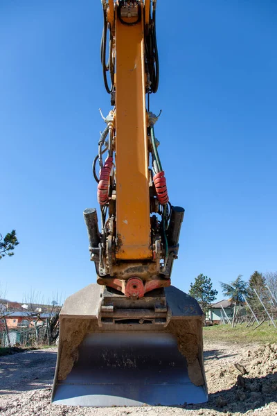 Road construction vehicle at Construction Site. Close-up of the shovel of a Excavator loader machine. vertical image
