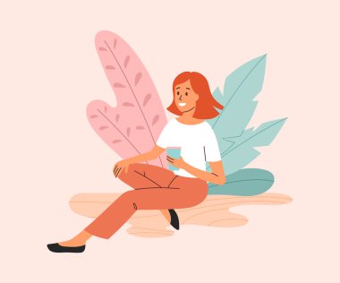 Şirin gülümseyen genç bayan elinde bir fincan kahveyle oturuyor.