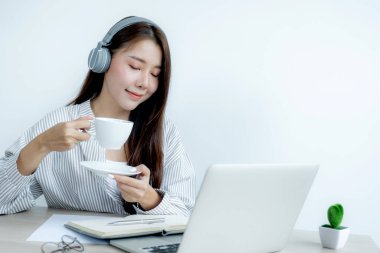 Genç Asyalı öğretmenler kahve içerler ve evlerinden internet üzerinden öğretmenlik yaparlar, COVID virüs hastalıkları sırasında sosyal mesafeli öğretim kavramı.