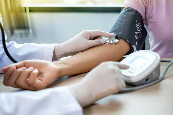 Dokter Mengevaluasi Pasien Dengan Stetoskop Monitor Tekanan Darah Dan Mencatat — Stok Foto