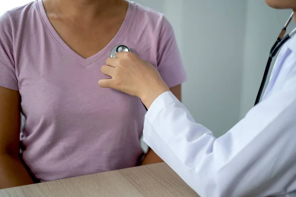 Doctor evaluates the patient with a stethoscope and records the results.