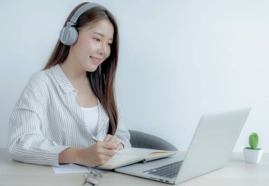 Genç kız öğrenci dizüstü bilgisayar dersi izlerken not alıyor online sınıf video konferansı eğitimi evden yeniden öğreniyor.
