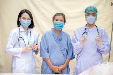 2 kadın doktor ve kıdemli hasta COVID 19 salgınından dolayı maske takıyordu..