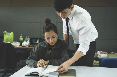 Öğrenci mutlu çift kütüphanede ders veriyor. Genç Asyalılar birlikte vakit geçiriyorlar. Üniversite yaşamında yaşam tarzı.