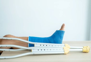 Kırık kemikleri ameliyat sonrası yürümek için koltuk değneği kullanıyor..