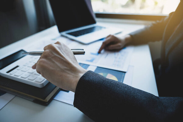 Businesswomen bookkeeper hand use calculator and laptop doing account for paying tax on white desk in working office.