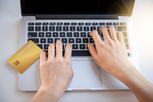 Consumer woman hand using laptop for online shopping according to discount products from home and spending pay via credit card.