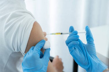 Doktorun elinde şırınga vardı ve virüsün yayılmasını önlemek için klinikteki bir hastayı aşılamak üzereydi..