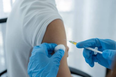 Doktorun elinde şırınga vardı ve virüsün yayılmasını önlemek için klinikteki bir hastayı aşılamak üzereydi..