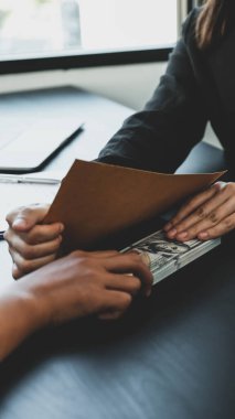 İş kadını devlet memurlarına rüşvet veriyor iş projeleri için sözleşmeler imzalıyor, parayı zarfa koyuyor, yolsuzluk ve rüşvet karşıtı fikirler üretiyor..