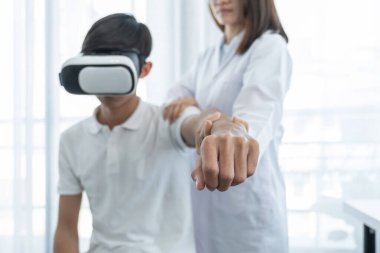 VR kutusu olan hasta erkek eli, elini uzatarak fizyoterapi yapan kadın doktor. Teknoloji kavramı, sanki bir doktor eve tedavi için gelmiş gibi hissettirdi..