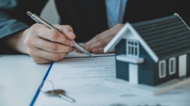 Emlakçı, iş sözleşmesini, kirayı, satın almayı, ipoteği, krediyi ya da ev sigortasını alıcıya açıkladıktan sonra el imzası..