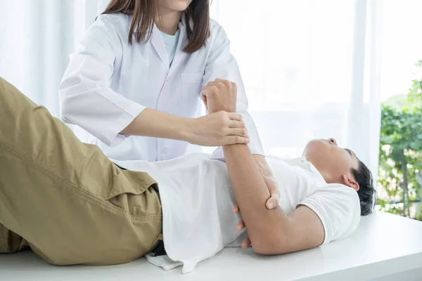 Médico Femenino Manos Haciendo Fisioterapia Extendiendo Brazo Paciente Masculino — Foto de Stock