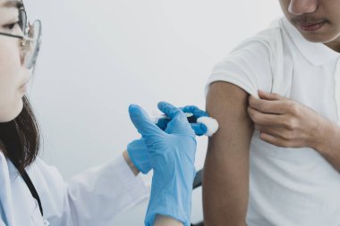 Doktorun elinde şırınga vardı ve virüsün yayılmasını önlemek için klinikteki bir hastayı aşılamak üzereydi..