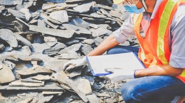 Müteahhit güvenlik endüstrisi projesinde çalışıyor. İnşaat alanındaki taşın büyüklüğünü ve kalitesini kontrol edin..