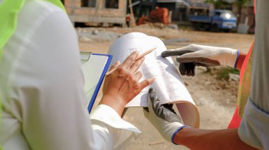 Ev planı, Mühendis Müteahhit Ekibi iş güvenliği projesiyle buluşuyor ve inşaat alanında tasarımı kontrol ediyor..