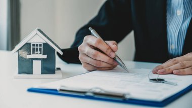 Emlakçı, iş sözleşmesini, kirayı, satın almayı, ipoteği, krediyi ya da ev sigortasını alıcıya açıkladıktan sonra el imzası..