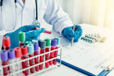 Doktor el kayıtları kan testi sonuçları ve hastanın ilaç kullanımı dosyada, tıbbi kontrol konsepti.