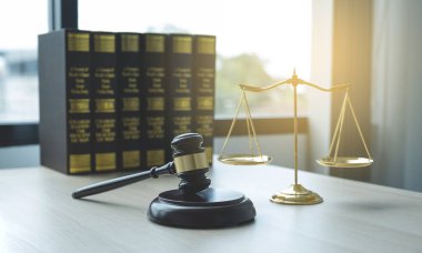 Gavel çekiç, adalet terazisi ve hukuk ders kitabı hukuk bürosunda hukuki danışmanlık hizmeti sağlamakla suçlanıyor..