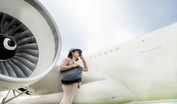 Happy travel passenger Asia woman Standing in front of the plane.