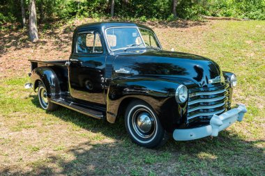 Gainesville, Georgia USA - 13 Haziran 2020 1950 model Chevrolet kamyonet 3100 model, parlak siyah boyalı, güneşli bir günde açık havada sergilenmek üzere çimlerin üzerine park edilmiş beyaz metal tampon.