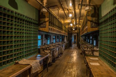 Duluth, Georgia USA - September 7, 2019  Inside of a railway post office mail train car restored to original condition looking down through the sorting and bag area in low lighting clipart