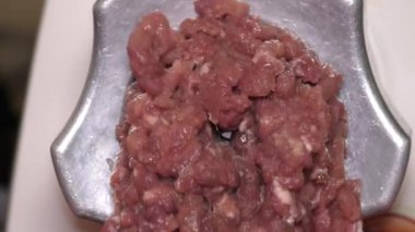 Kıyma makinesi çiğ et öğütür.