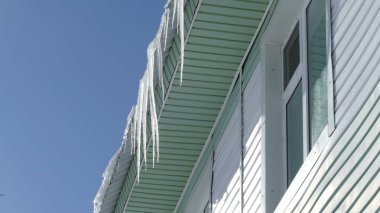 Buz saçakları çatıdan sarkıyor. 