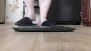 Bir insan ağırlığını ölçmek için tartıya çıkar. 