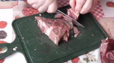 Ev yemeği pişirme süreci. Aşçı çiğ geyik etini bıçakla keser. Sağlıklı gıda konsepti