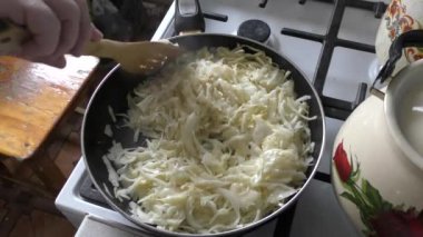 Ev yemeği pişirme süreci. Aşçı lahana kızartıyor. Sağlıklı gıda konsepti