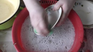 Aile yemeğinden sonra mutfakta bulaşıkları yıkayan kadın.