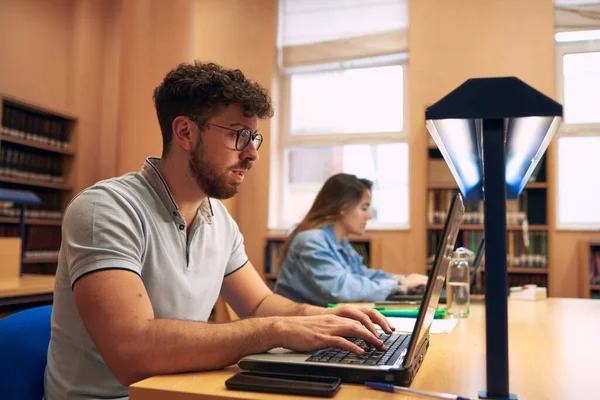 Ragazzo Utilizza Computer Portatile Mentre Studia Biblioteca — Foto Stock