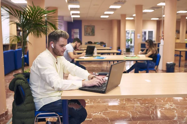 Ragazzo Seduto Che Lavora Con Suo Portatile Biblioteca — Foto Stock