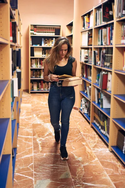 Giovane Ragazza Con Una Maschera Sta Leggendo Libri Nella Biblioteca — Foto Stock