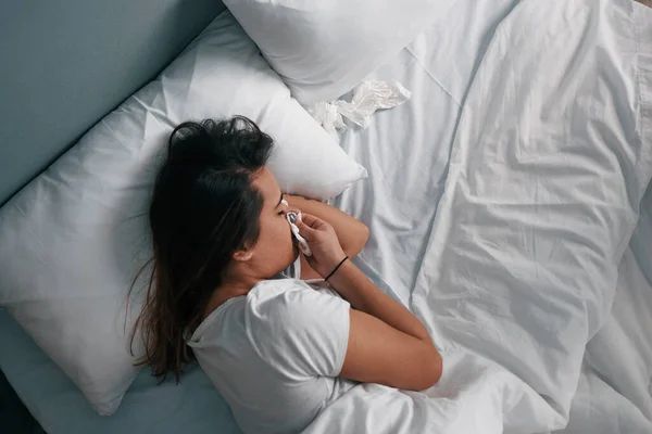 A sick young woman in bed in quarantine