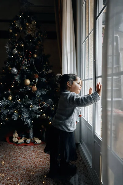 祖父母は彼らの小さな孫娘とクリスマスツリーを飾る — ストック写真