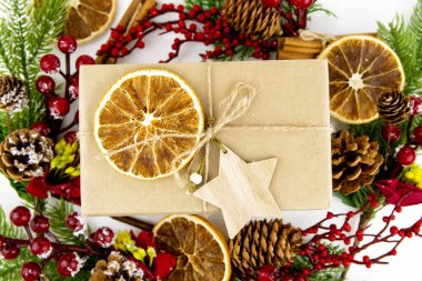 Ahşap yıldız ve kurutulmuş portakallı el sanatları hediye kutusunun yakın çekimi. Noel için çevre dostu ambalaj konsepti.