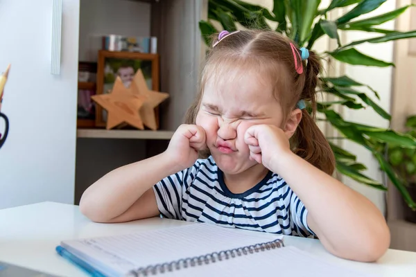 Distance learning online education. A preschool age girl studies at home at the computer and does her homework. quarantine coronavirus.