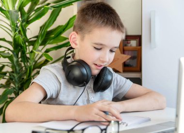 Uzaktan öğrenme çevrimiçi eğitim. Bir öğrenci evde bir bilgisayarın başında ders çalışıyor ve okul ödevi yapıyor. Koronavirüsü karantinaya alın. 