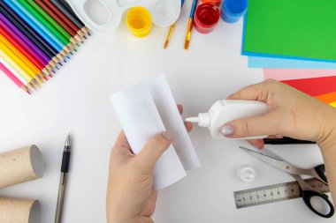 Yeni yıl dekorasyonu. DIY ve çocukların yaratıcılık konsepti. Adım adım: tuvalet kağıdı ve kağıdından bir inek yap. Üçüncü adım rulo ve yapıştırıcıyı sar.